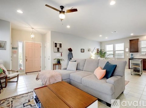 A living room with a grey couch and a wooden coffee table.