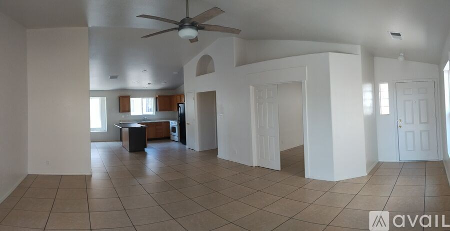 A spacious room with a ceiling fan and tiled flooring.