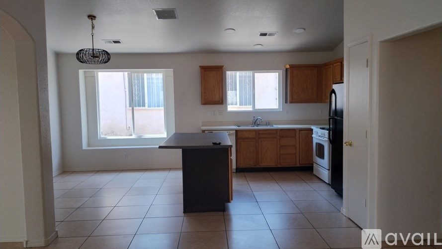 A kitchen with a black island and wooden cabinets.