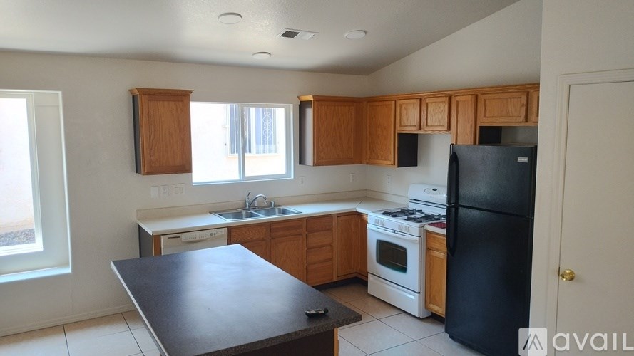 A kitchen with wooden cabinets and black appliances.