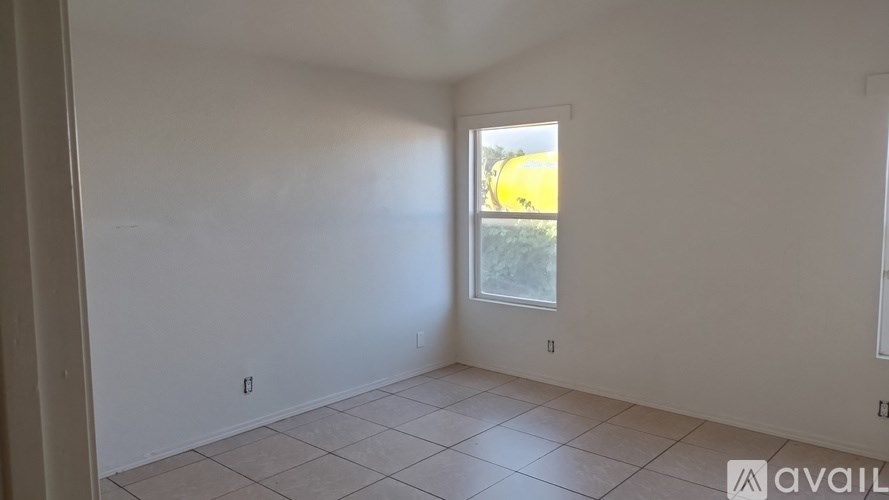 A room with a window and tiled floor.