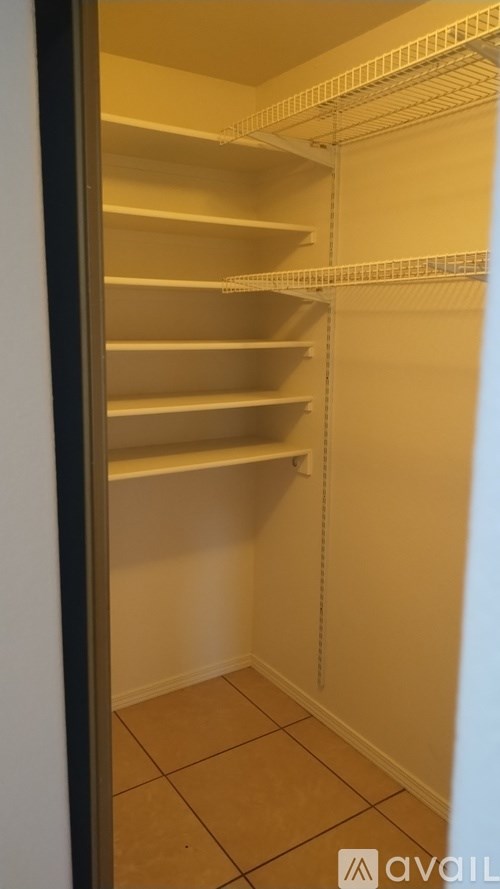 Empty pantry with shelves and tiled floor.