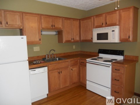 A kitchen with wooden cabinets and white appliances.