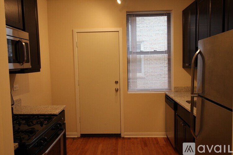 A kitchen with a white door and a black stove.