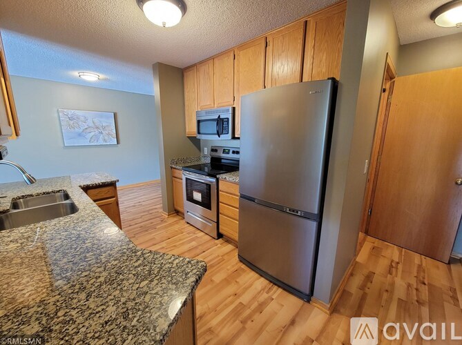 A kitchen with a granite counter top and stainless steel appliances.