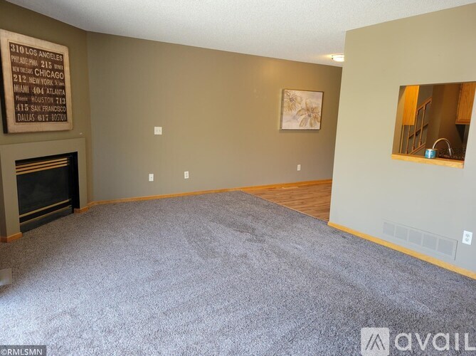A living room with a fireplace and a painting on the wall.