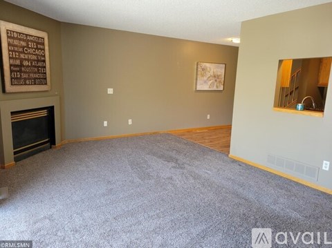 A living room with a fireplace and a painting on the wall.