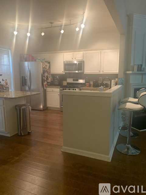 A kitchen with white cabinets and a wooden floor.