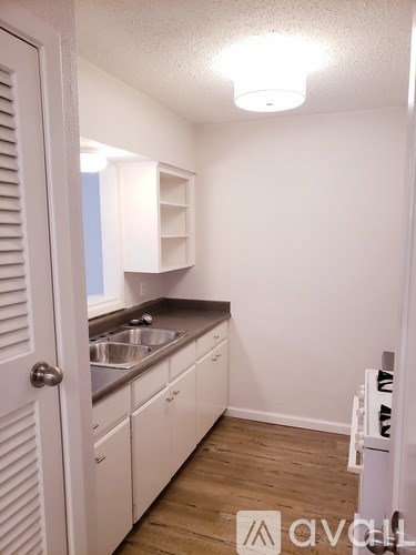 A kitchen with white cabinets and a sink.