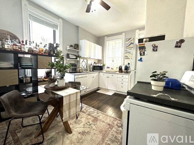A kitchen with a black countertop and white cabinets.