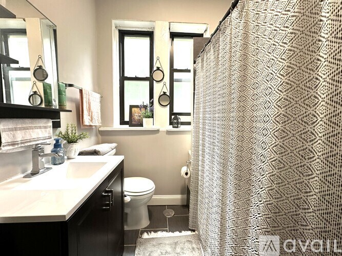 A bathroom with a shower curtain and a toilet.