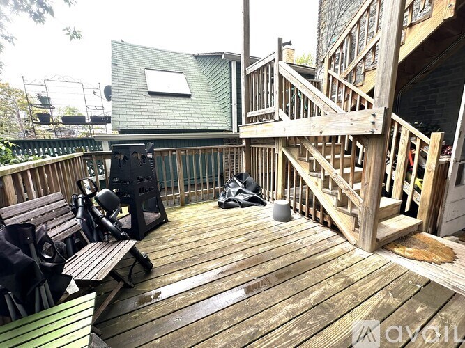 A wooden deck with a bench and a grill.