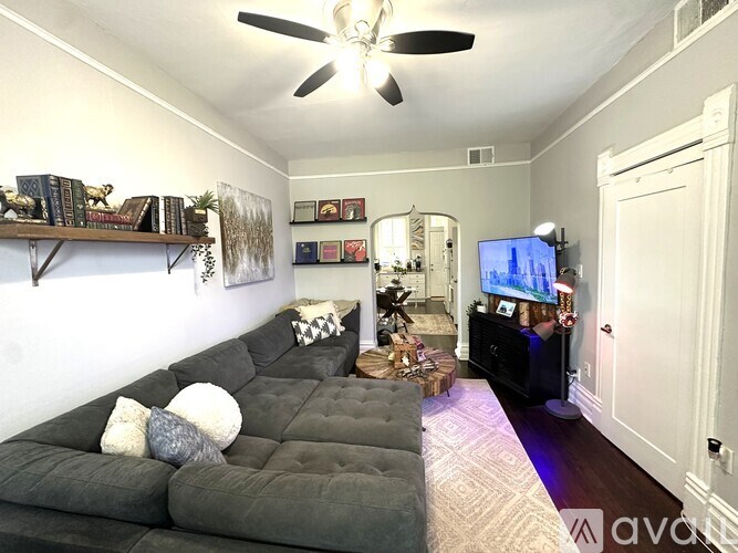 A living room with a grey sofa and a television.