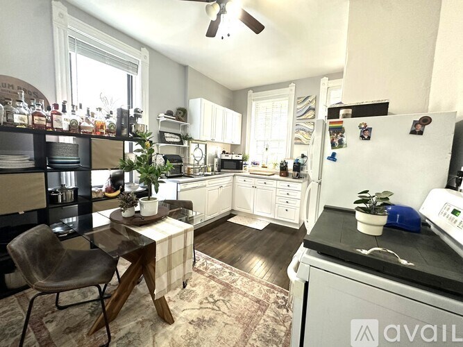 A kitchen with a refrigerator, a table, and a chair.