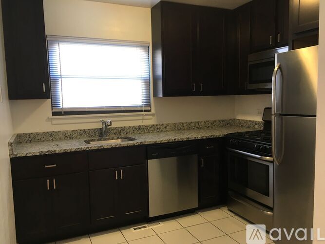 A kitchen with black cabinets and stainless steel appliances.