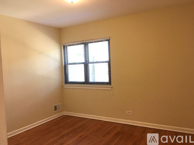 A room with a window and wooden flooring.
