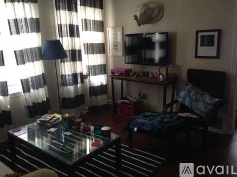 A living room with a glass table and a television on the wall.