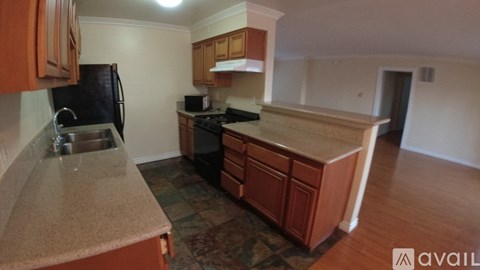 A kitchen with wooden cabinets and a granite countertop.