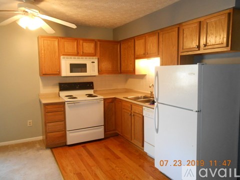 A kitchen with wooden cabinets and a white refrigerator.