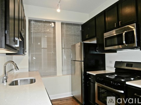 A kitchen with black cabinets and stainless steel appliances.