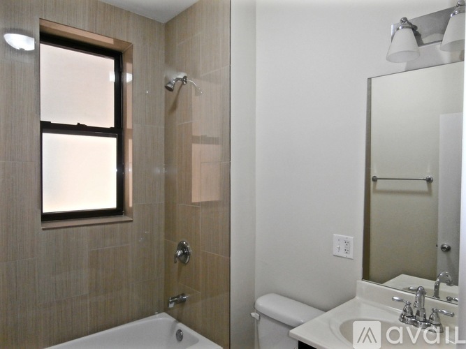 A bathroom with a tub, toilet, and sink.