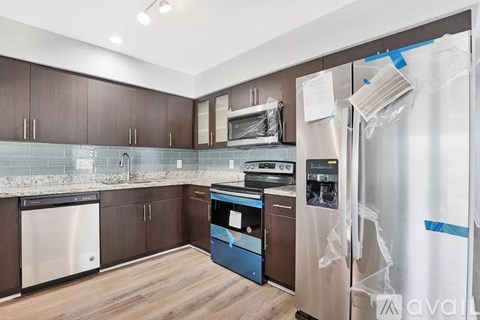 A kitchen with a refrigerator covered in plastic wrap.