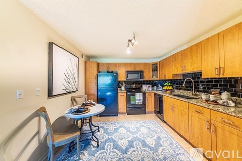 A kitchen with a blue refrigerator and a dining table with chairs.