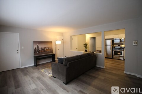 A living room with a grey couch and a wooden floor.