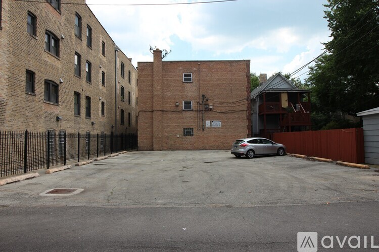 A parking lot with a car and a building in the background.