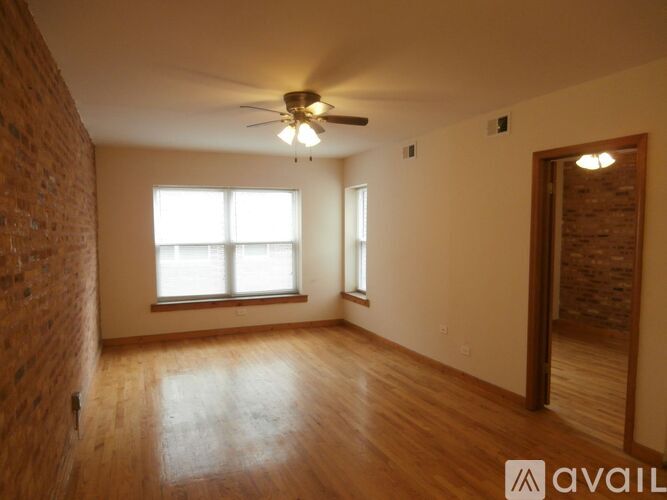 A room with wooden floors and a ceiling fan.