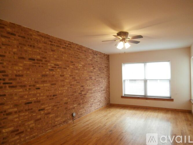 A room with a brick wall and a ceiling fan.