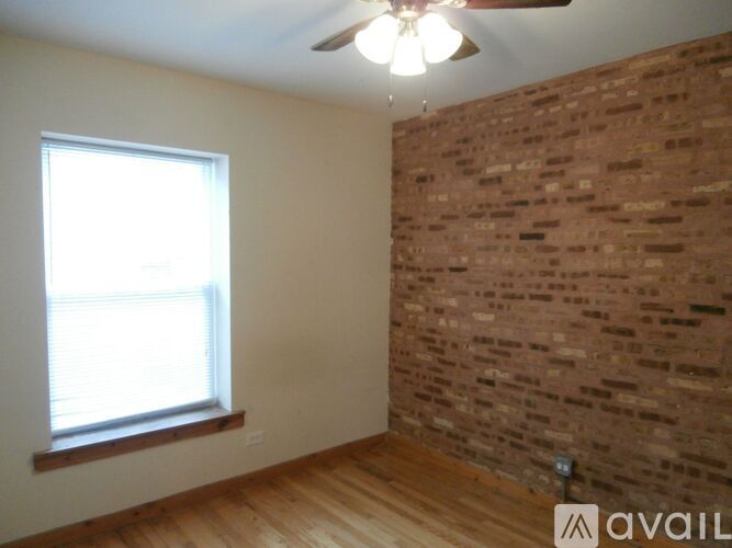 A room with a brick wall and wooden flooring.