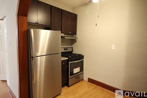 A kitchen with a stainless steel refrigerator and black appliances.
