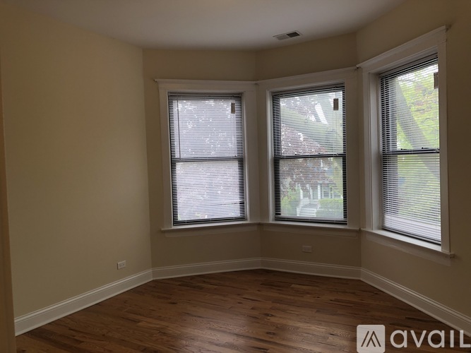 A room with wooden floors and two windows.