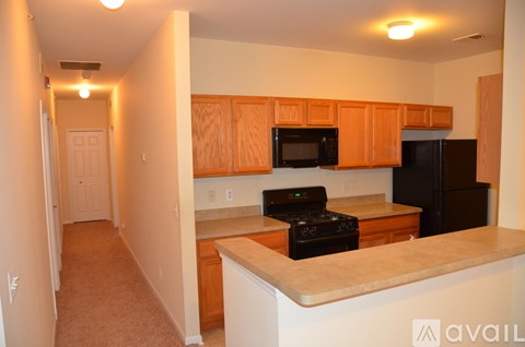 A kitchen with wooden cabinets and black appliances.