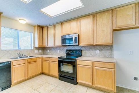 A kitchen with wooden cabinets and black appliances.