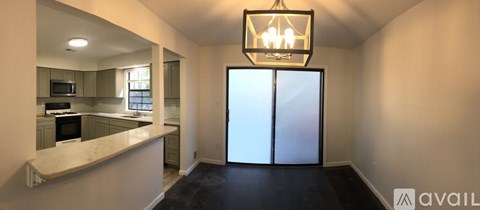 A kitchen with a white counter top and a chandelier hanging from the ceiling.