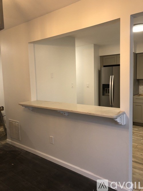A white framed mirror on a white wall.
