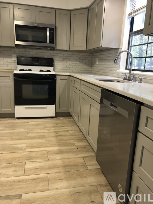 A kitchen with a black oven and white cabinets.