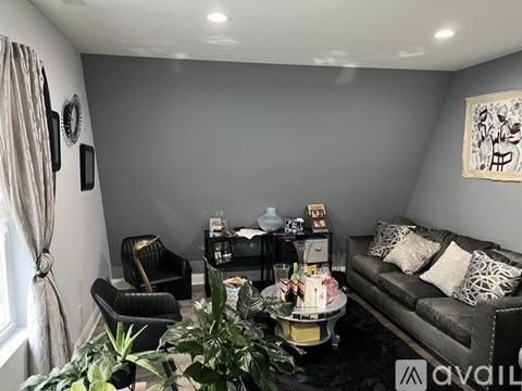 A living room with a grey couch, a coffee table, and a painting on the wall.