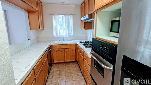 A kitchen with wooden cabinets and a stainless steel oven.