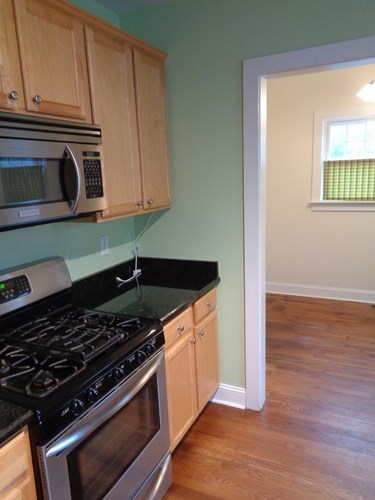 A kitchen with a stove and microwave.
