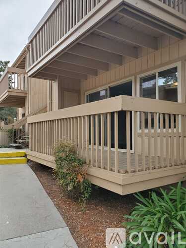 A beige house with a balcony and a small garden.