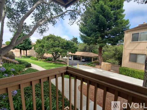A balcony view of a residential area with houses and trees.