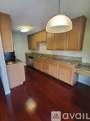 A kitchen with wooden cabinets and a marble countertop.