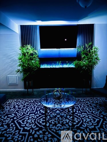 A table with a glass top is in the middle of a room with a patterned carpet.