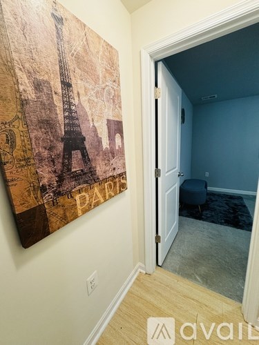 A room with a Paris themed painting on the wall.