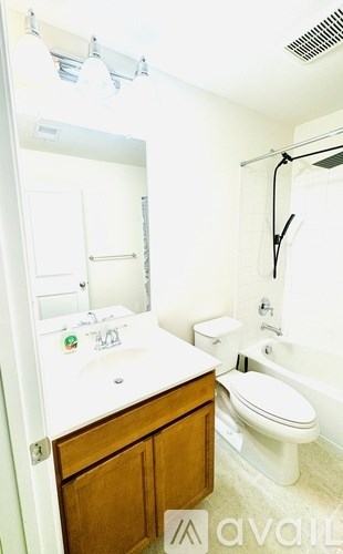 A white bathroom with a toilet, sink, and shower.