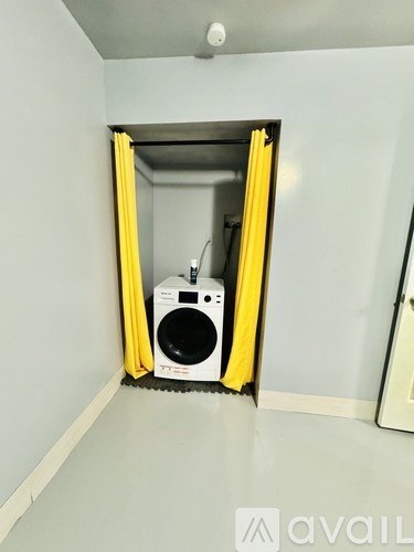 A room with a washing machine in a doorway.
