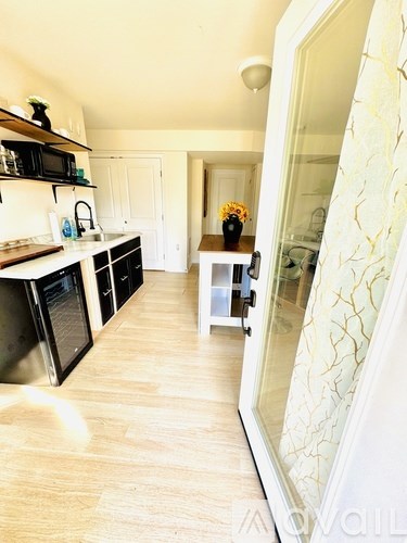 A kitchen with a wooden floor and white walls.